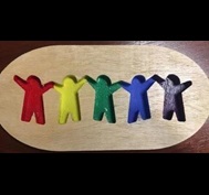 Wood with cut-outs of people shapes.  Each person is a different color of the rainbow.