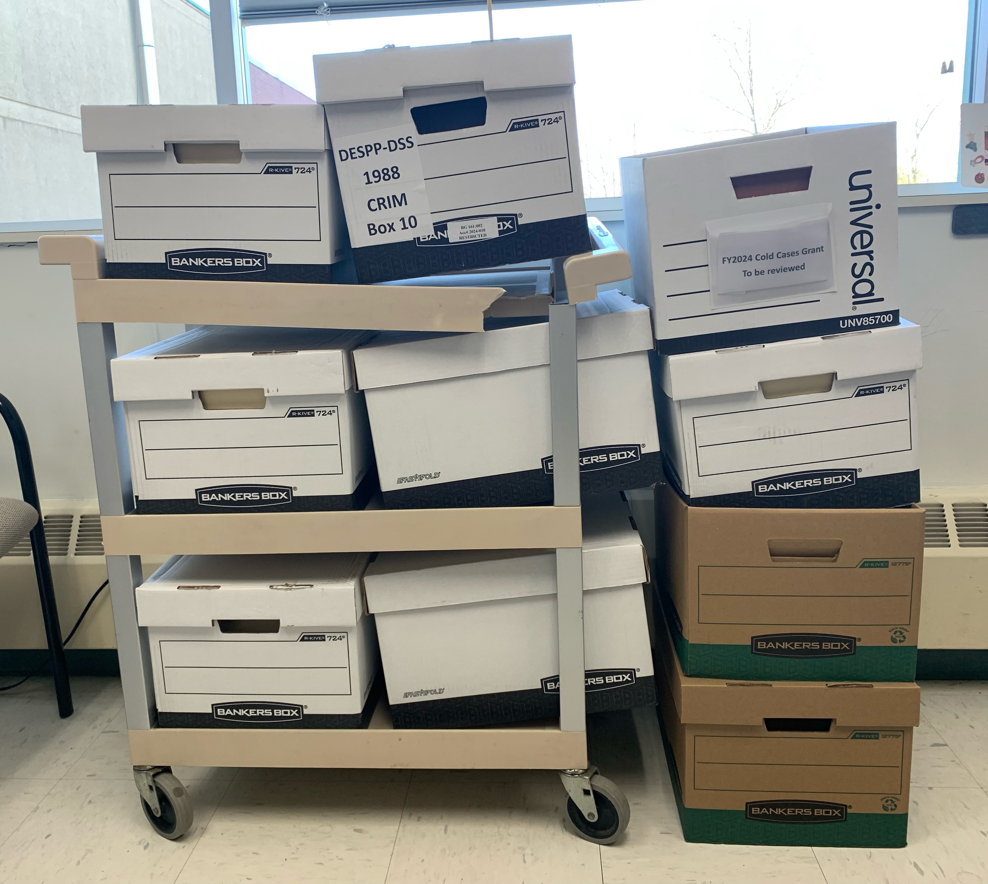 A stack of paper boxes containing cold case files