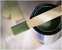 Image of paint can with green paint and stirring stick