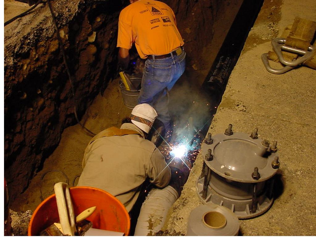 workers laying pipe in hole