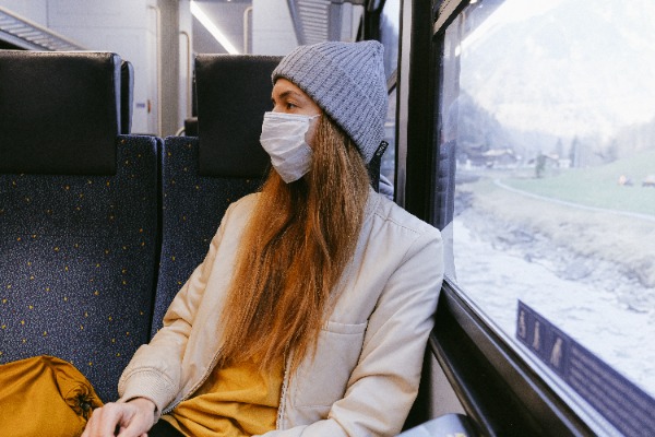 Young woman on a train with a winter view outside.