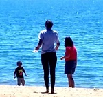 Photo of a child on a beach with two parents