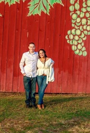 Kally and Zander in white shirts and jeans in front of a red barn
