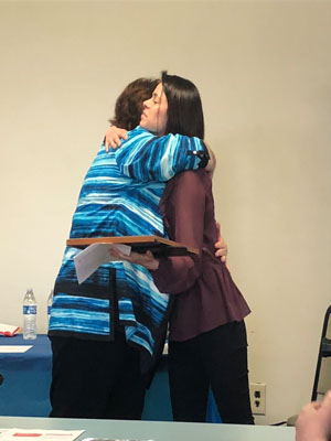 Caitlin Daikus accepts her certificate from Izabella Pulvermacher, DDS Dental Coordinator