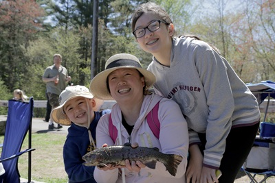 Family of anglers showing off their catch on free fishing day.