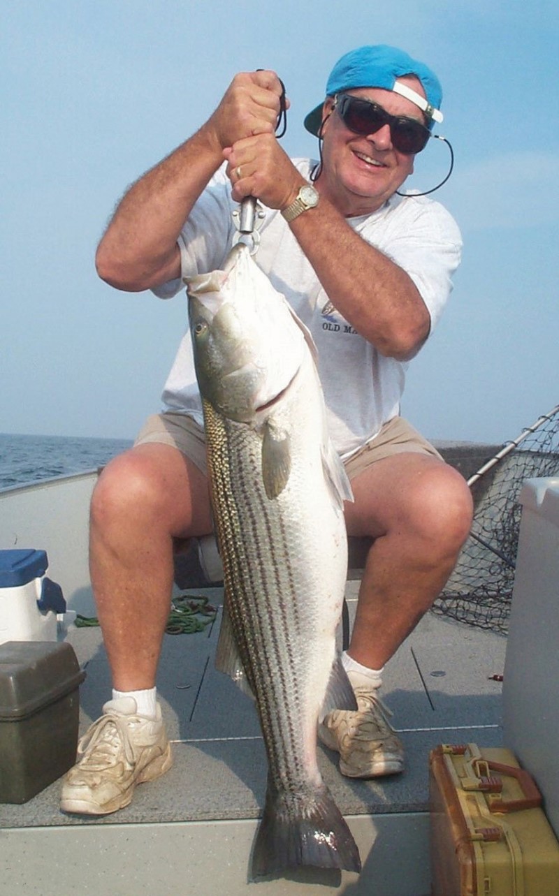 Angler with large striped bass.