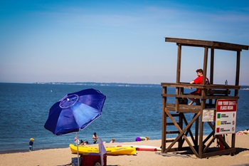 A lifeguard monitors beach goers in a state swimming area