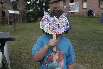 Child wearing a bat mask she created.