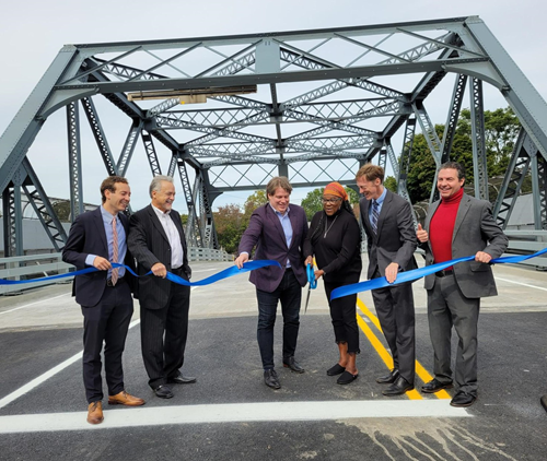 Group of people cut ceremonial blue ribbon on the Ferry Street Bridge in New Haven