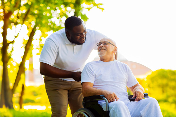 Man helps older man in wheelchair