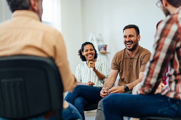 An adult man talking with random people from the group therapy