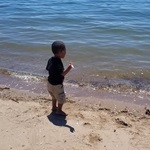 Photo of Jayden on a beach, right next to the water 