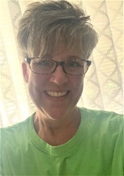 Image of DCF Nurse Kimberly Kanaitis, MSN RN, smiling brightly in a green shirt