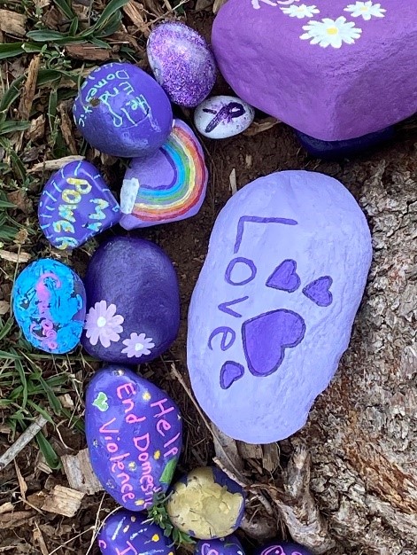 Rocks painted blue and purple; one has a rainbow and reads "Love"