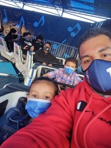 Photo of Joseph and his daughter on a ride.  Both wear masks.