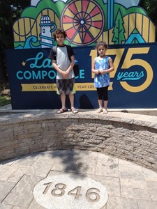Photo of the two children in front of a fair sign