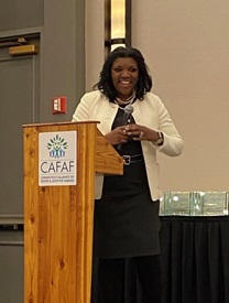 Commissioner Dorantes smiling and standing at a podium at the CAFAF conference