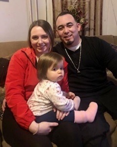 Vince on a couch with his wife and child