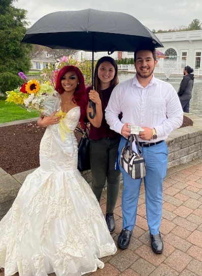 A person and person posing for a picture with an umbrella Description automatically generated with low confidence