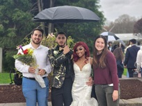A group of people posing for a photo under an umbrella Description automatically generated