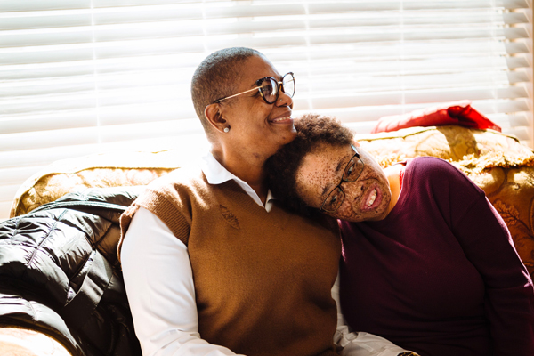 Two people hugging on couch 