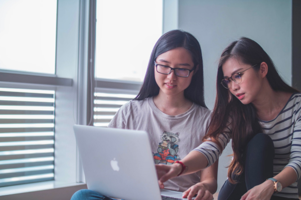 Two girls using laptop