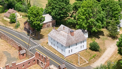 Aerial view of Viets Tavern, a large white colonial building located across from Newgate Prison on the East side of the street. 