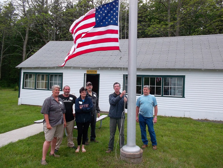 CCC Alumni Holding Flag at Re-Opening CCC Museum