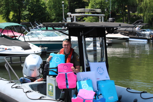 Picture of Officer Kiely holding life jackets in a boat