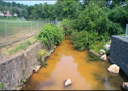 Upstream of Heminway Pond Dam prior to removal. Photo credit: Upstream of Heminway dam with orange-colored water