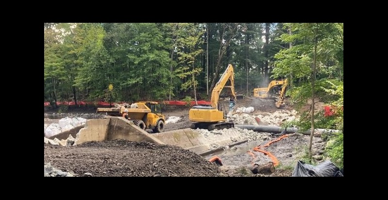 The removal of Strong Pond Dam. Photo credit: Braden Lynn Excavators and a dump truck removing concrete from Strong Pond Dam