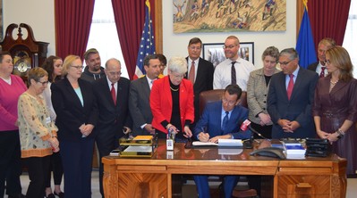 Governor Malloy signs legislation at his desk