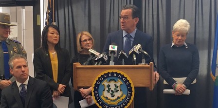 Governor Malloy speaking at podium at the Connecticut State Police headquarters
