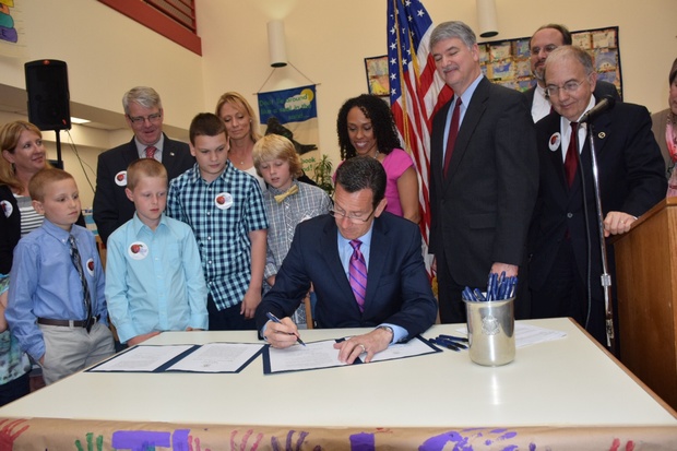 Joined by students, state officials, and lawmakers, Governor Malloy signs into law legislation establishing the Office of Early Childhood as an official state agency. (May 28, 2014)