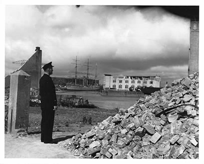German naval training ship Horst Wessel sits amid the ruins of Bremerhaven, where it had been towed at teh wind of World War II. It was refurbished there, commissioned by teh Coast Guard as the Eagle