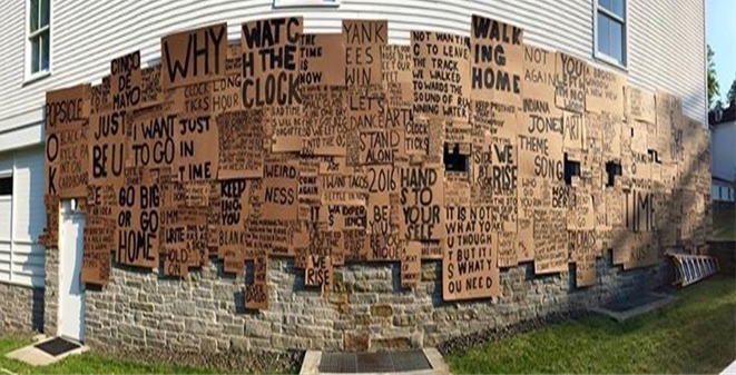 A wall covered in signs made from cardboard