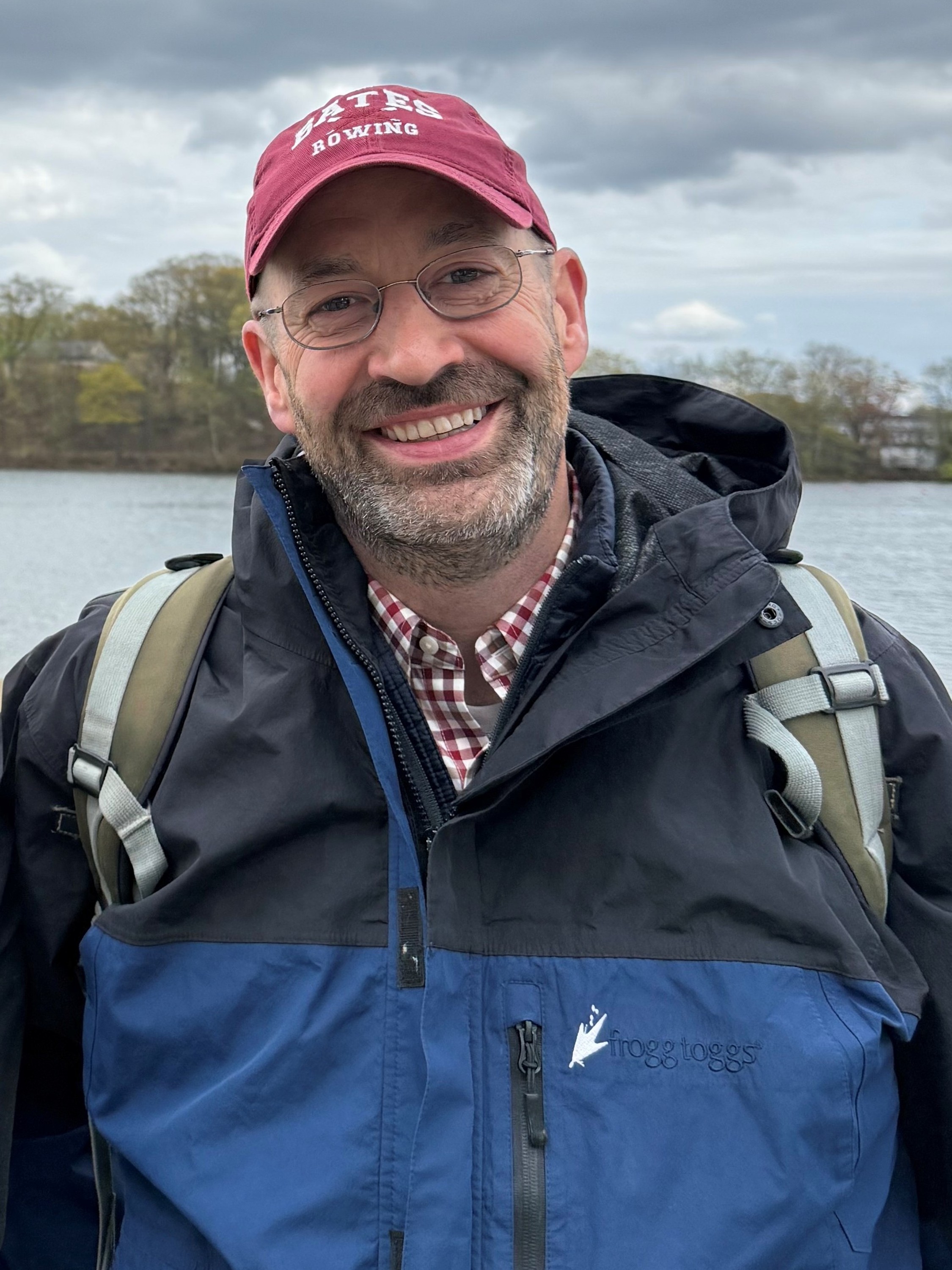 Headshot photo of Scott Williams, Ph.D. wearing a red hat and a raincoat.