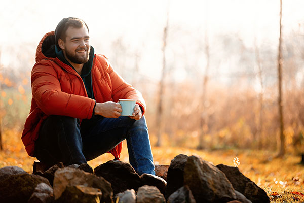 man drinking coffee outdoors on a cold morning