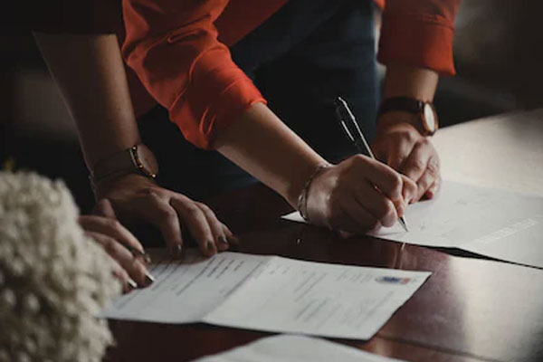 people signing paperwork