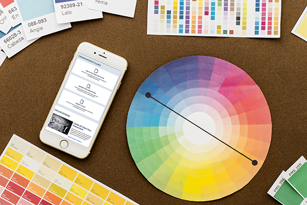 A smartphone on a table displaying a CT website with various color swatches and a circle color palette surrounding it.