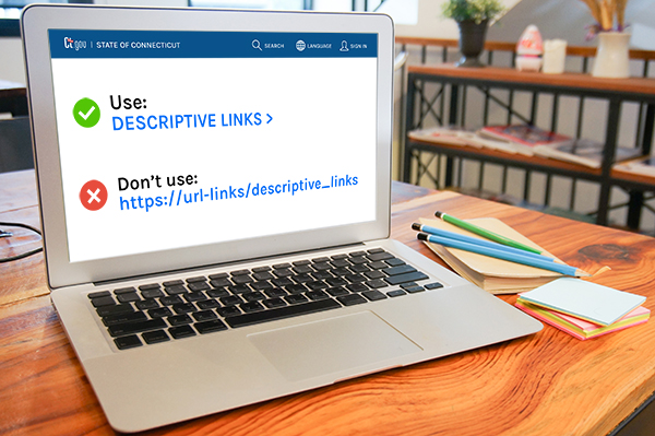 An open laptop on a desk that contains a descriptive link with a green check mark and a url link with an x mark, both links are in blue text.