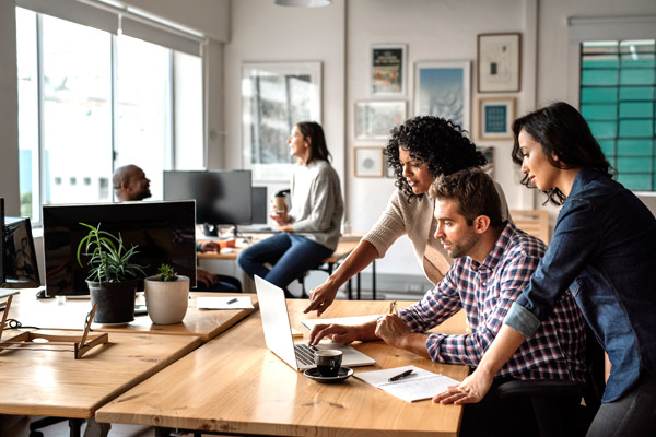 Three employees looking at a computer.