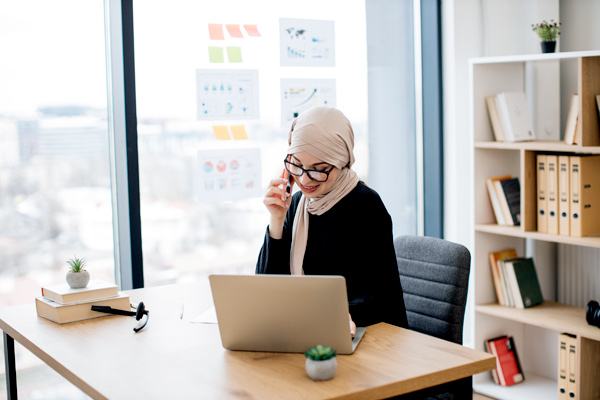 Woman on phone at computer.