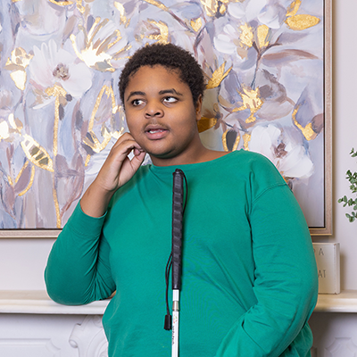 a visually impaired boy poses with his sight cane