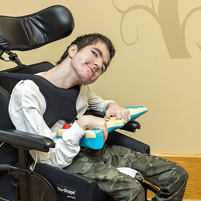 photograph of a medically complex boy smiling