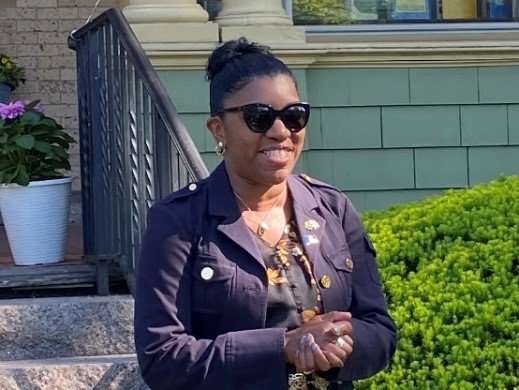 Photo of Commissioner Dorantes smiling in sunglasses outside with her hands clasped