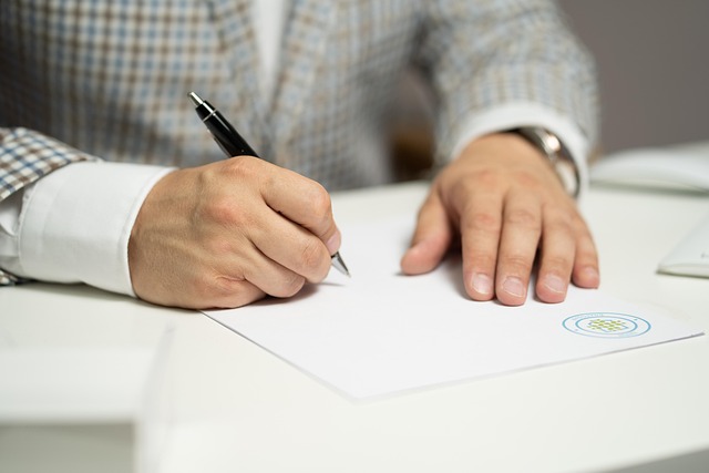 close up of hands signing a contract