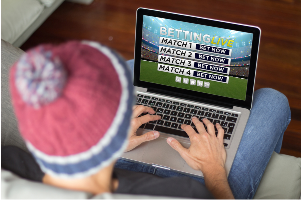 Image of individual sports wagering on their laptop for various soccer matches