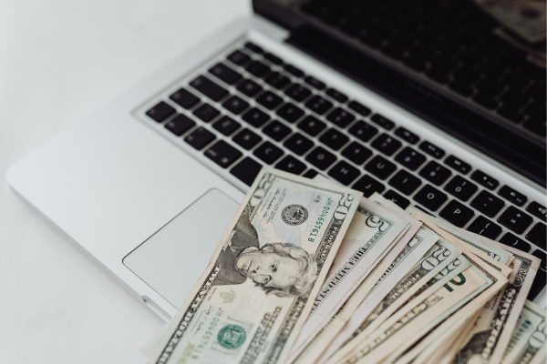 Decorative image of a stack of 20 dollar bills on a computer keyboard