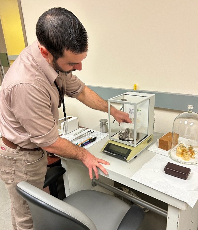 DCP Metrologist, Chris David, demonstrates measuring a 5-pound “standard,” which is used to calibrate scales throughout the state.